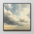 The Heavenly Drift Canvas Art features a framed print of a cloudy sky with soft blue, gray, and cream tones as light breaks through above a faint horizon—an ideal vintage accent for adding serenity to any living room.