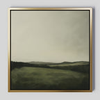 The Hills at Dusk Canvas Art features a misty green landscape with rolling hills and an overcast sky. Its soft, blurred look and muted colors make it a perfect minimalist accent for your living room decor.