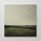 The Hills at Dusk Canvas Art features a serene, misty landscape with soft green fields and distant rolling hills beneath a gray sky—perfect minimalist wall art print to create calming living room decor.