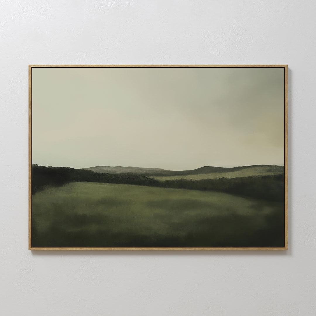 The Hills at Dusk Canvas Art – Horizontal features a minimalist misty green landscape with rolling hills under a cloudy sky, elegantly displayed on a white wall as stylish living room decor.