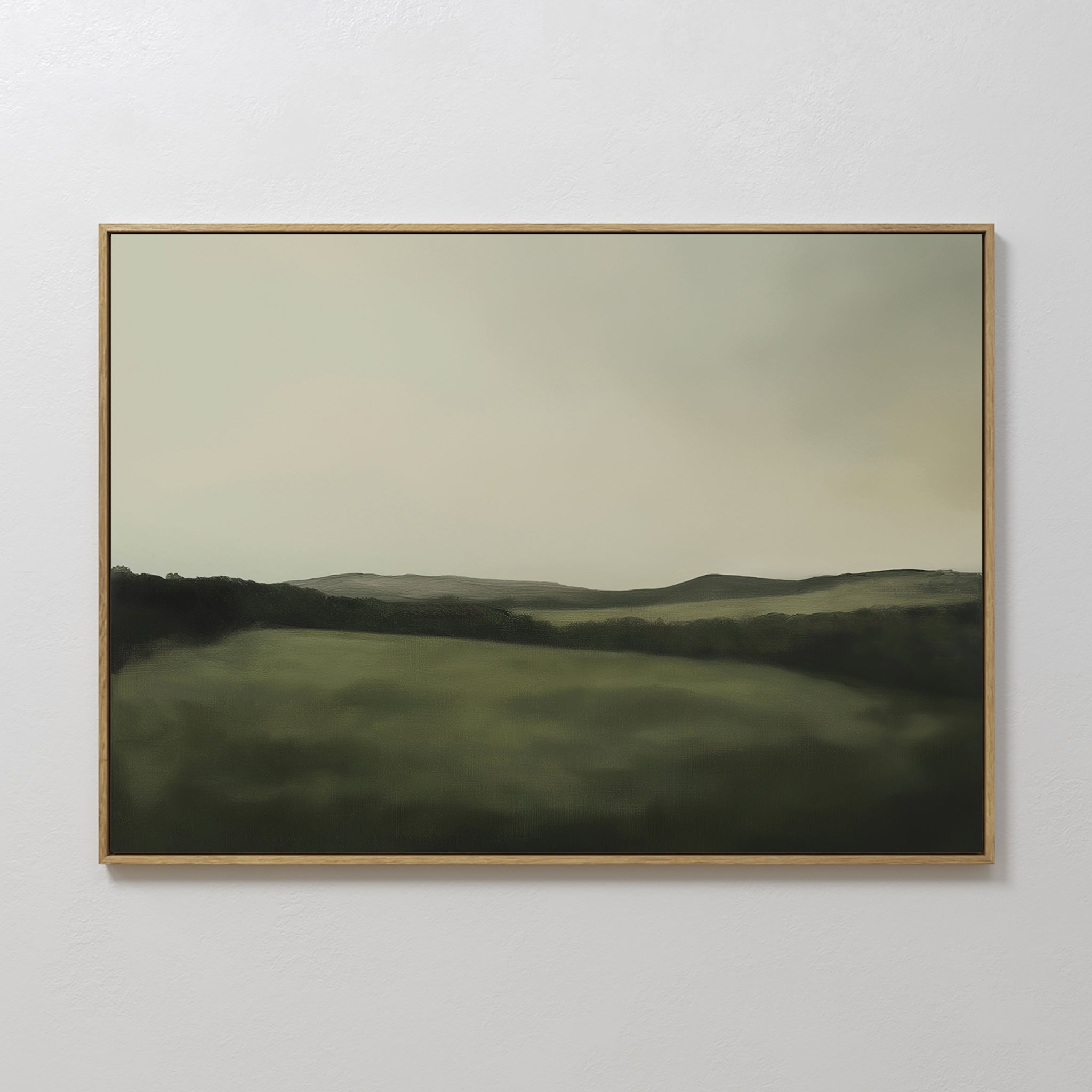 The Hills at Dusk Canvas Art – Horizontal features a minimalist misty green landscape with rolling hills under a cloudy sky, elegantly displayed on a white wall as stylish living room decor.