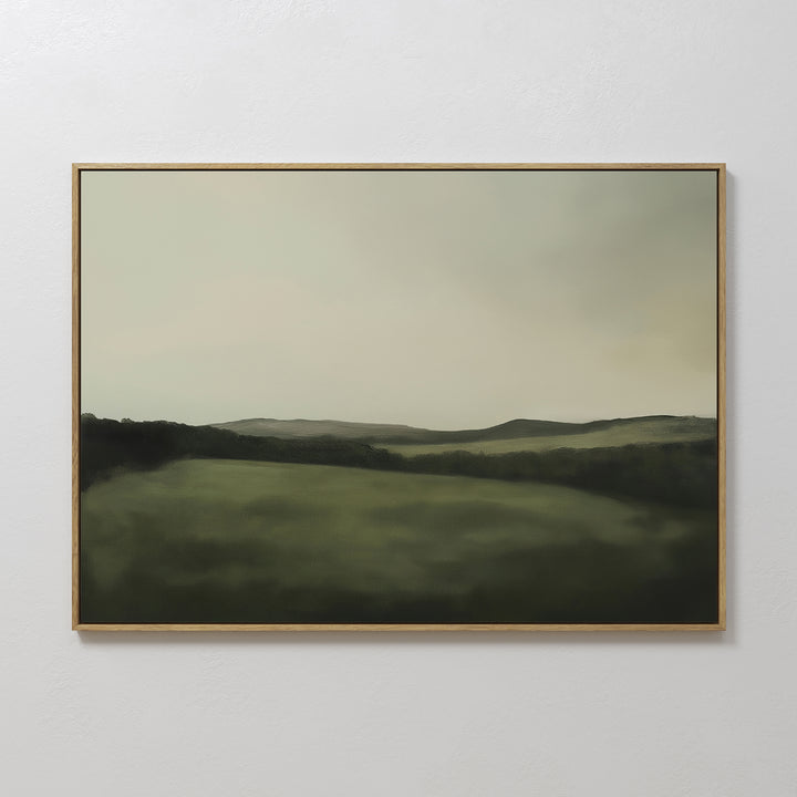 The Hills at Dusk Canvas Art – Horizontal features a minimalist misty green landscape with rolling hills under a cloudy sky, elegantly displayed on a white wall as stylish living room decor.