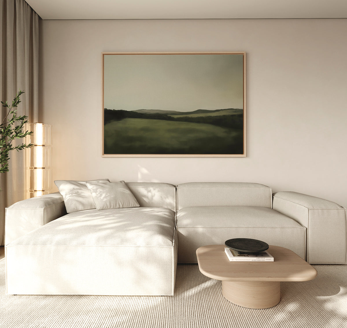 A modern living room with a light beige sectional sofa, a wooden coffee table, the Hills at Dusk Canvas Art – Horizontal on the wall, and a tall plant in the corner—all in neutral tones and bathed in natural light.