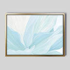 The Icy Petals Abstract Canvas Art features soft, flowing shapes in light blue and white, reminiscent of delicate petals on a gray background. Its simple gold frame adds modern, minimalist style, making it perfect wall art for living room decor.
