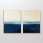 The Indigo Horizon Set of 2 features abstract wall art with blue-to-beige gradients in slim gold frames, evoking a calm seascape—perfect for adding modern elegance to your living room decor.