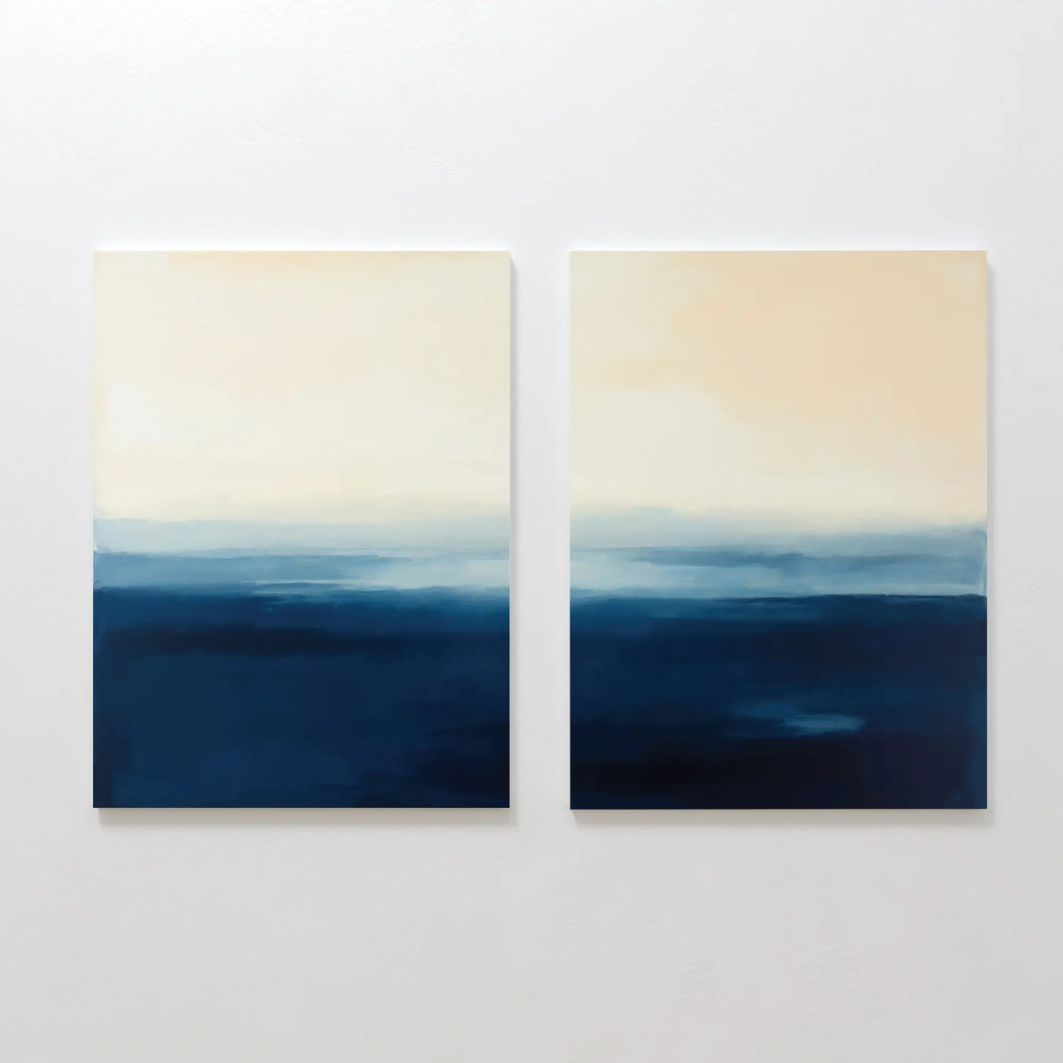 The Indigo Horizon Set of 2 features abstract paintings with soft beige and blue gradients, evoking a calm seascape—ideal wall art for modern living rooms or serene bedrooms.