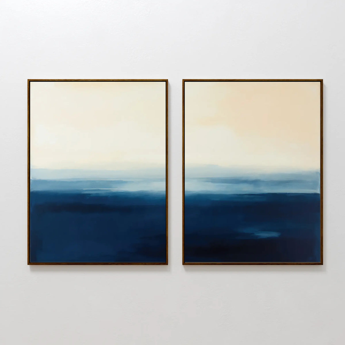 The Indigo Horizon Set of 2 features abstract art with cream blending into indigo blue, evoking a serene, misty seascape. Each piece is simply framed and perfect for adding modern style to your living room decor.