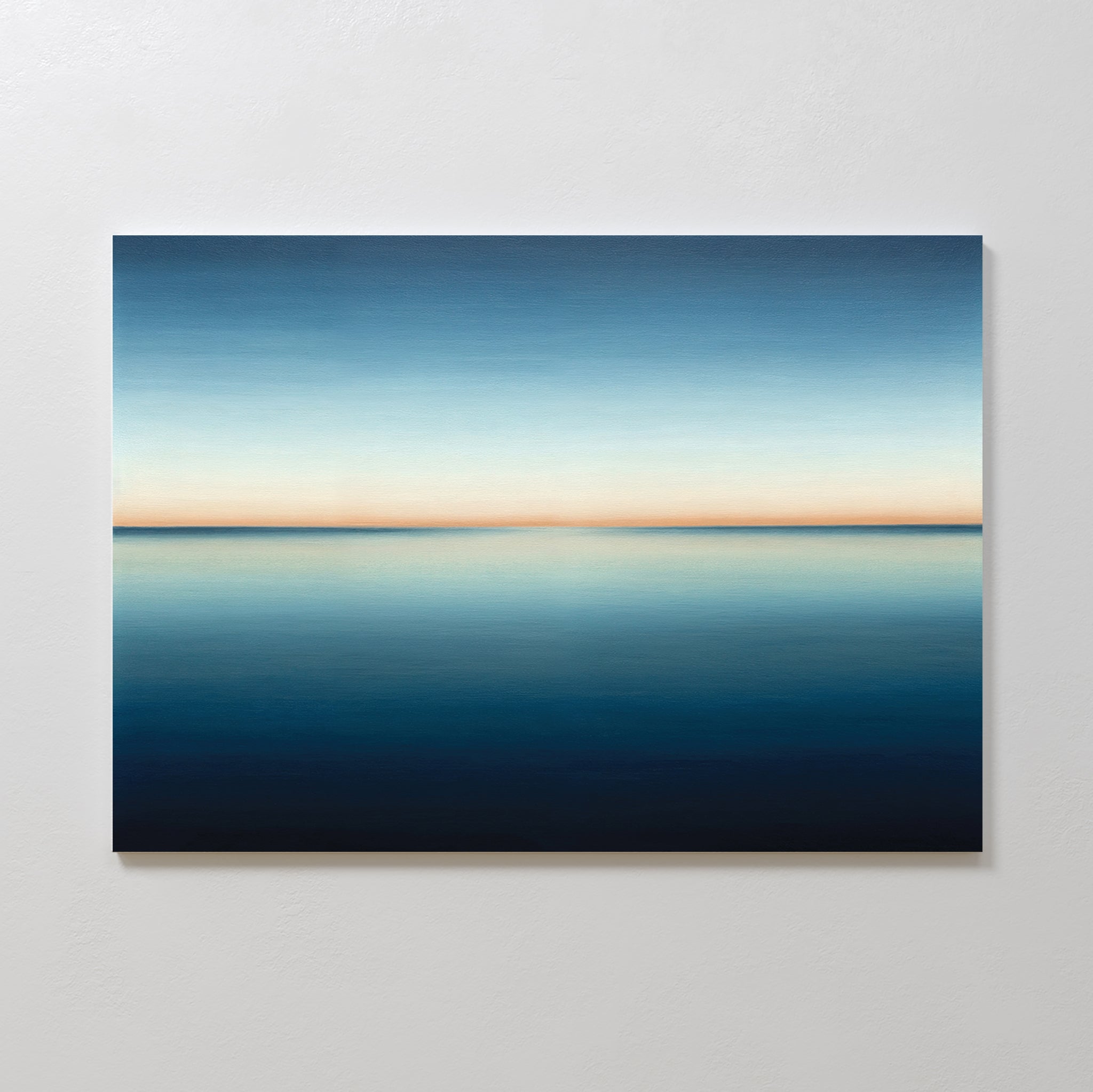 The Indigo Passage Canvas Art – Horizontal features a minimalist ocean under a gradient sky, blending deep blue to pale orange—ideal wall art to create a serene, peaceful vibe in any modern living room.
