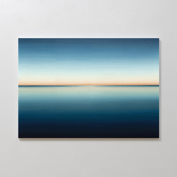 The Indigo Passage Canvas Art – Horizontal features a minimalist ocean under a gradient sky, blending deep blue to pale orange—ideal wall art to create a serene, peaceful vibe in any modern living room.