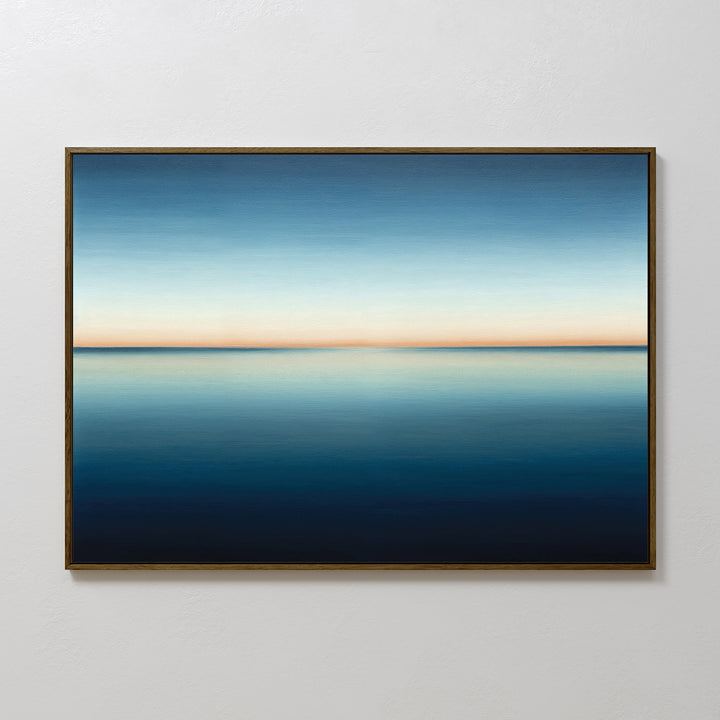 The Indigo Passage Canvas Art – Horizontal showcases a calm blue ocean under a gradient sky, blending deep blue to light orange. This minimalist wall art is perfect for adding peaceful, modern style to your living room decor.