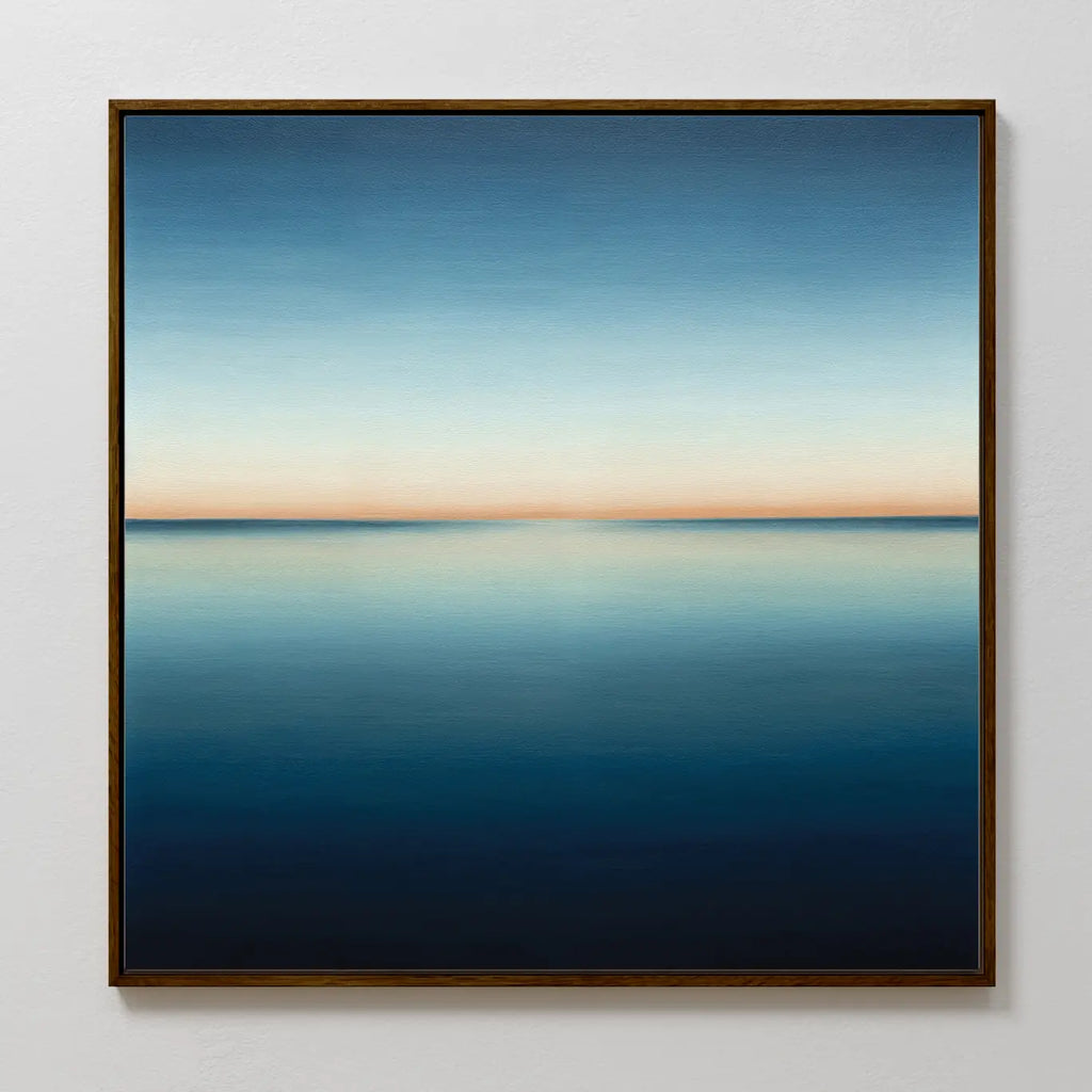 Indigo Passage Canvas Art features a serene seascape with a calm, reflective ocean and a gradient sky from deep blue to soft peach—perfect indigo wall art for enhancing modern living room decor.