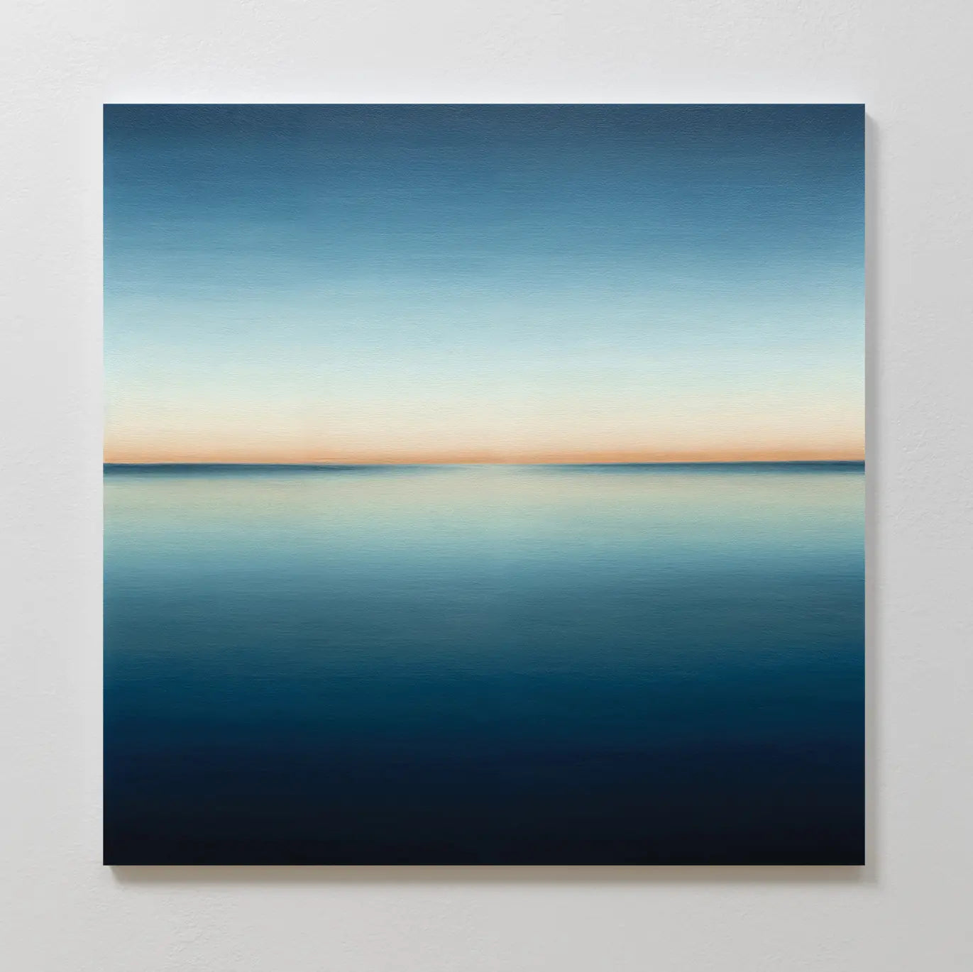 Indigo Passage Canvas Art features a minimalist scene of serene water merging with the sky, soft blue gradients, and warm light—ideal indigo wall art to enhance modern living room décor.
