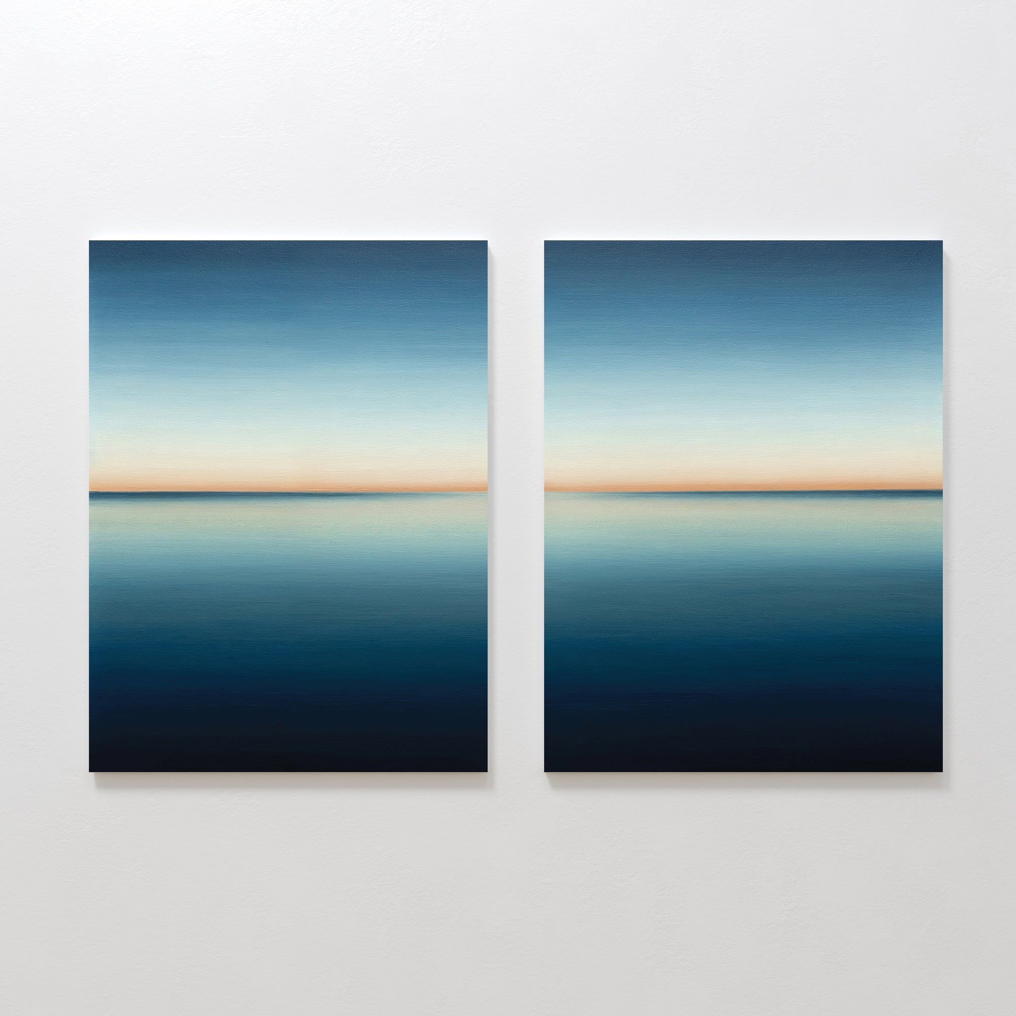 The Indigo Passage Set of 2 features square paintings with calm blue seascapes and soft orange horizons, creating serene minimalist wall art ideal for modern living room decor.