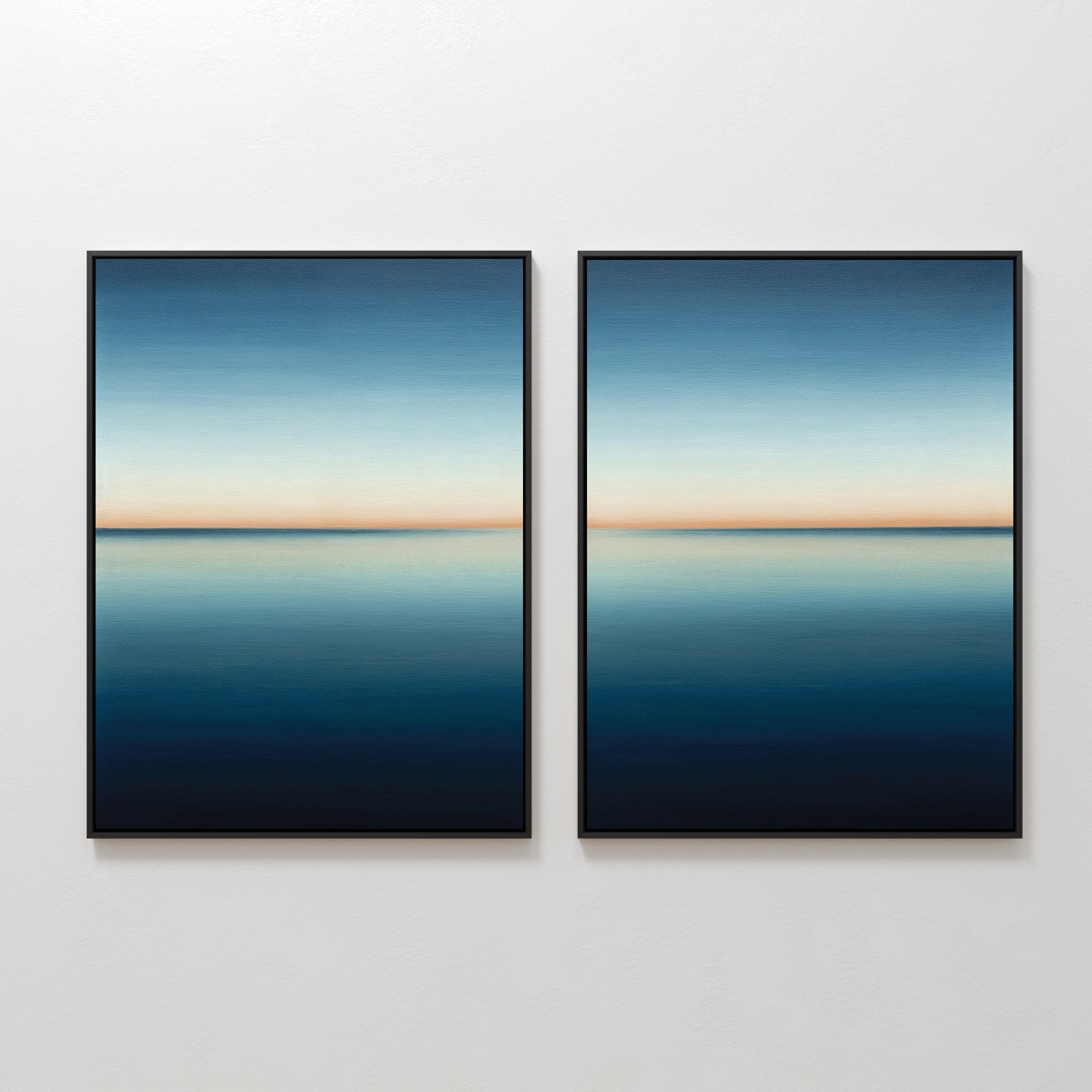 The Indigo Passage Set of 2 features framed paintings of a serene blue seascape with a clear horizon, hung side by side. This minimalist wall art adds tranquility and is ideal for enhancing modern living room decor.