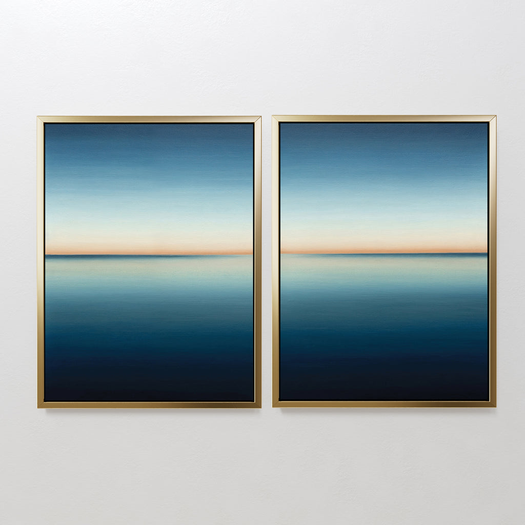 The Indigo Passage Set of 2 features framed abstract paintings with calm blue gradients and a thin orange horizon, creating serene, minimalist wall art perfect for modern living room decor.