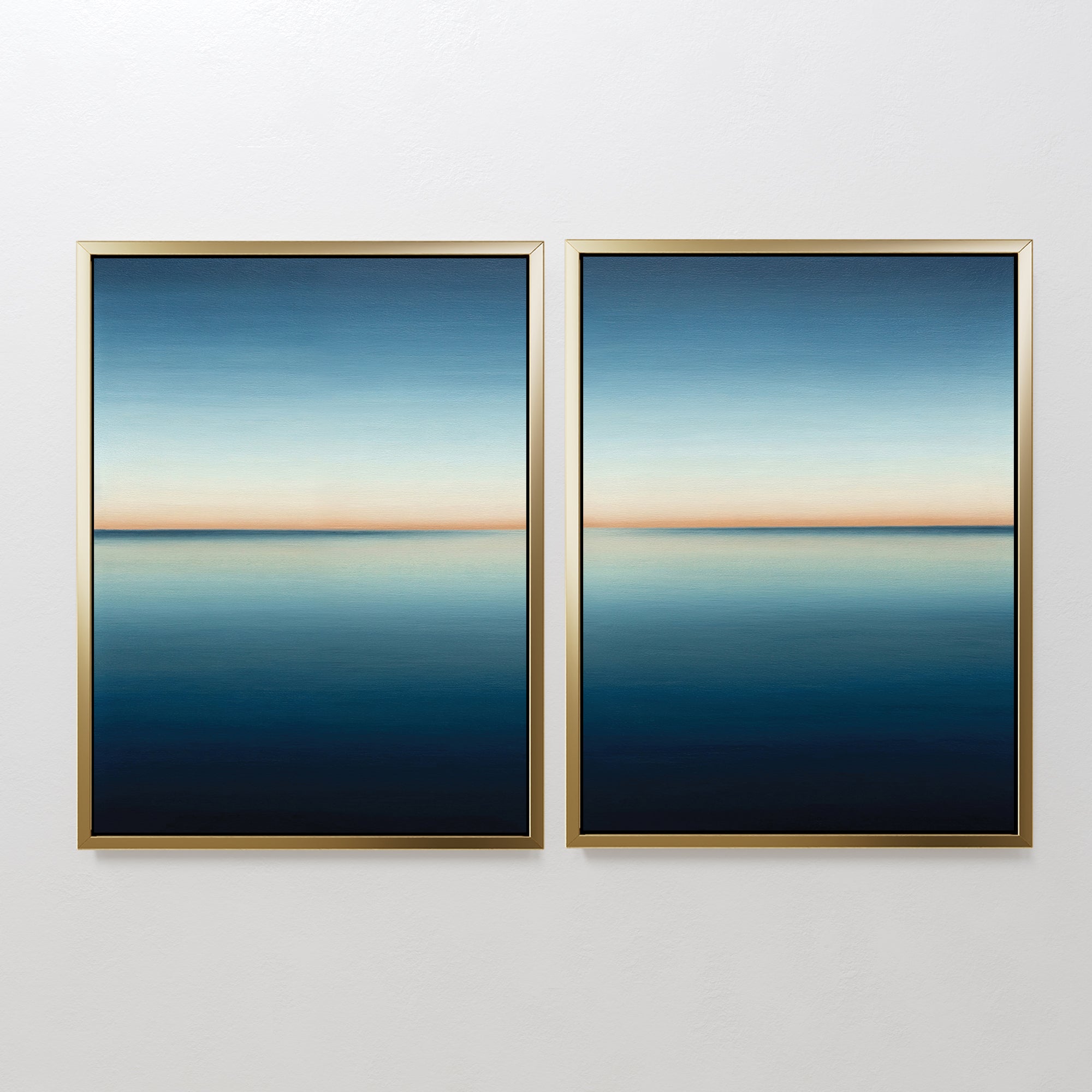 The Indigo Passage Set of 2 features framed abstract paintings with calm blue gradients and a thin orange horizon, creating serene, minimalist wall art perfect for modern living room decor.