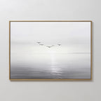 Into the Light Canvas Art – Horizontal: a minimalist framed painting of a serene gray and white seascape with sunlight on the water and five birds—ideal wall art for enhancing your living room decor.