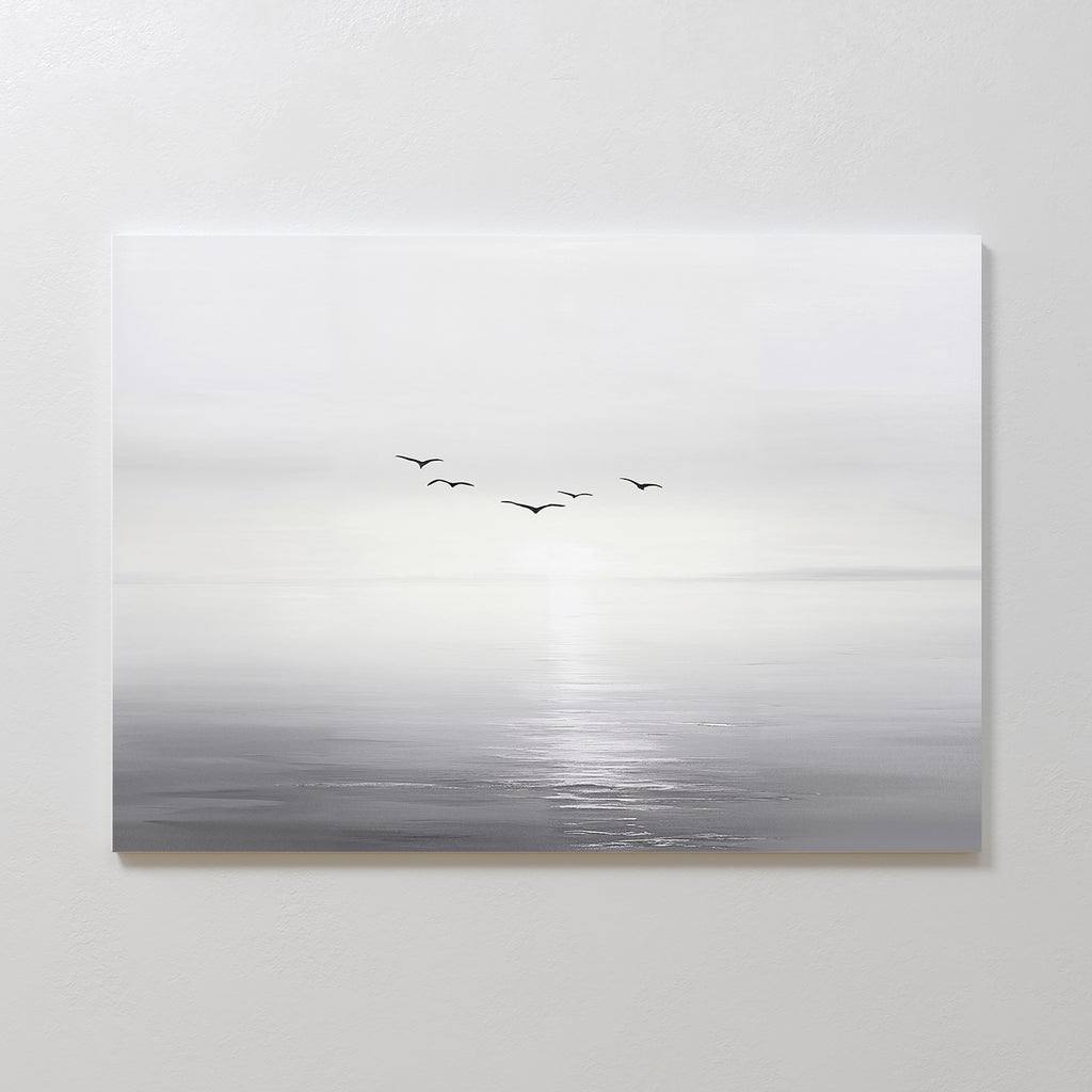 Into the Light Canvas Art – Horizontal features a minimalist, gray-toned seascape with five birds flying above gentle water, ideal as large wall art to create a serene ambiance in your living room on a plain white wall.