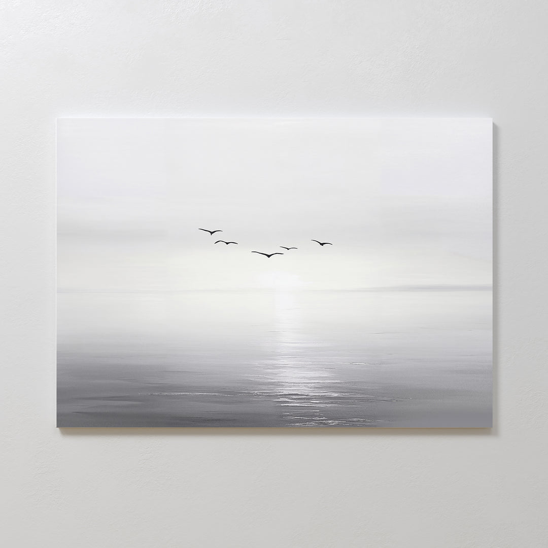 Into the Light Canvas Art – Horizontal features a minimalist, gray-toned seascape with five birds flying above gentle water, ideal as large wall art to create a serene ambiance in your living room on a plain white wall.