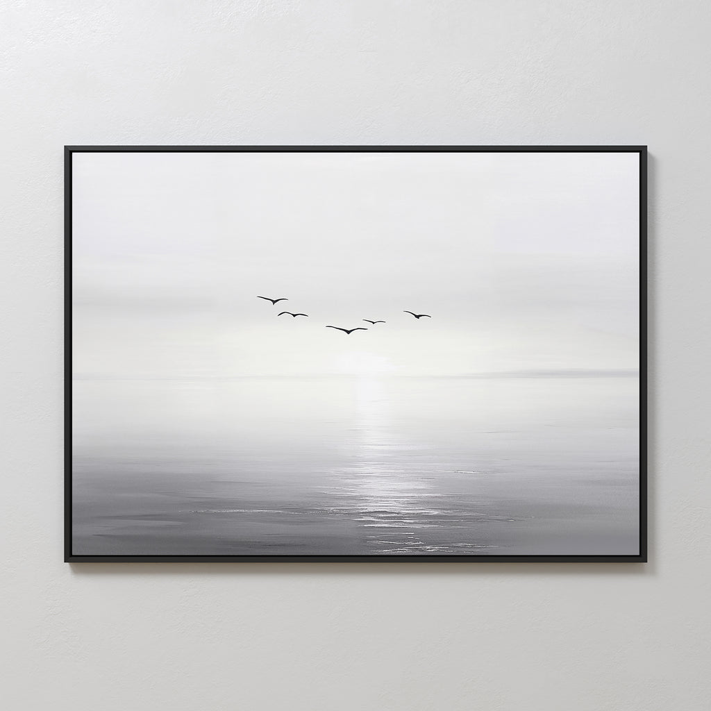 “Into the Light Canvas Art – Horizontal” is a framed minimalist wall art print featuring a black and white seascape with five birds flying above calm water and a soft, hazy horizon—ideal for living room decor.