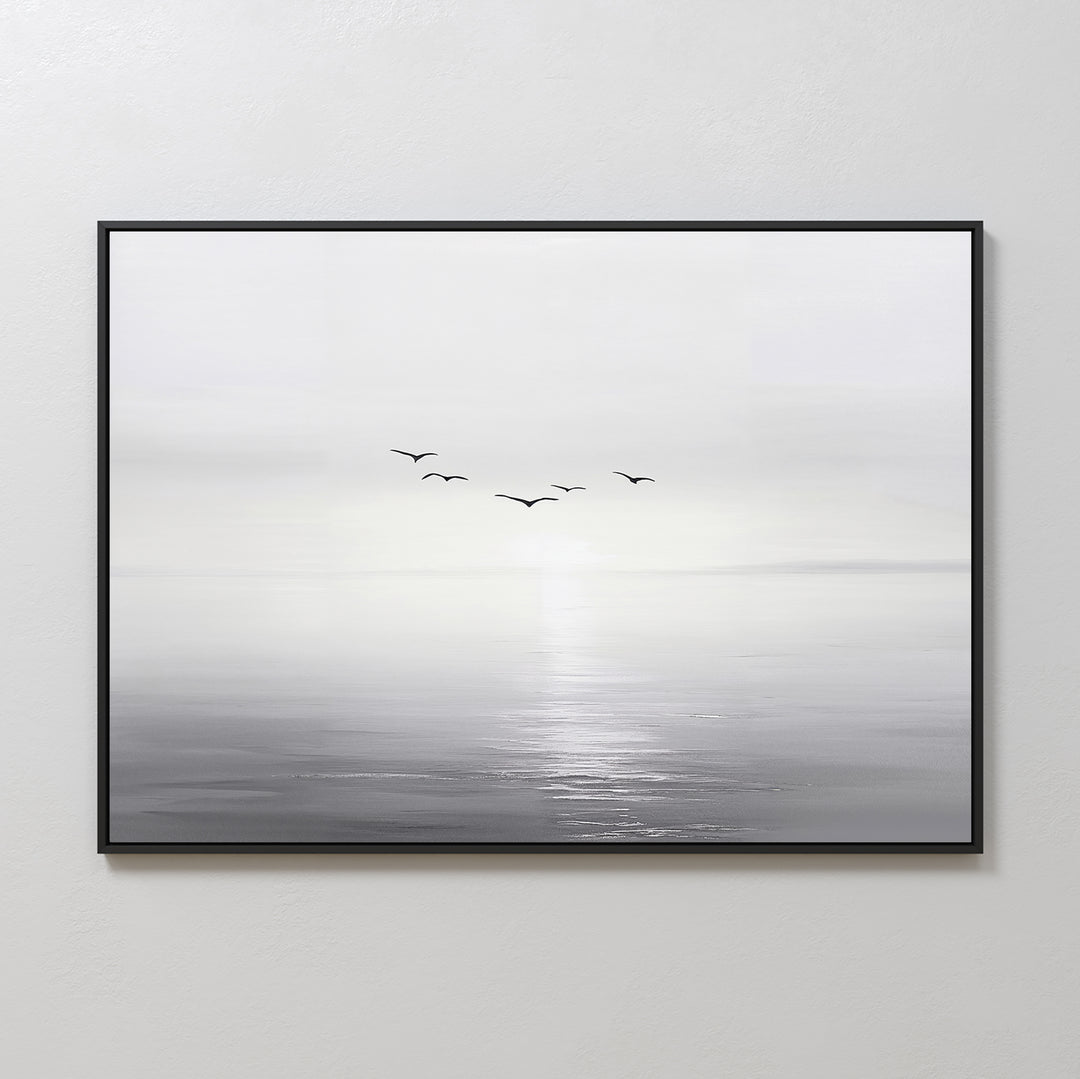 “Into the Light Canvas Art – Horizontal” is a framed minimalist wall art print featuring a black and white seascape with five birds flying above calm water and a soft, hazy horizon—ideal for living room decor.