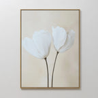 The Ivory Buds Canvas Art showcases two delicate white flowers with slender stems on a light beige background, framed in slim gold. Perfect for neutral-toned and minimalist interiors, this elegant wall art enhances any space with subtle sophistication.
