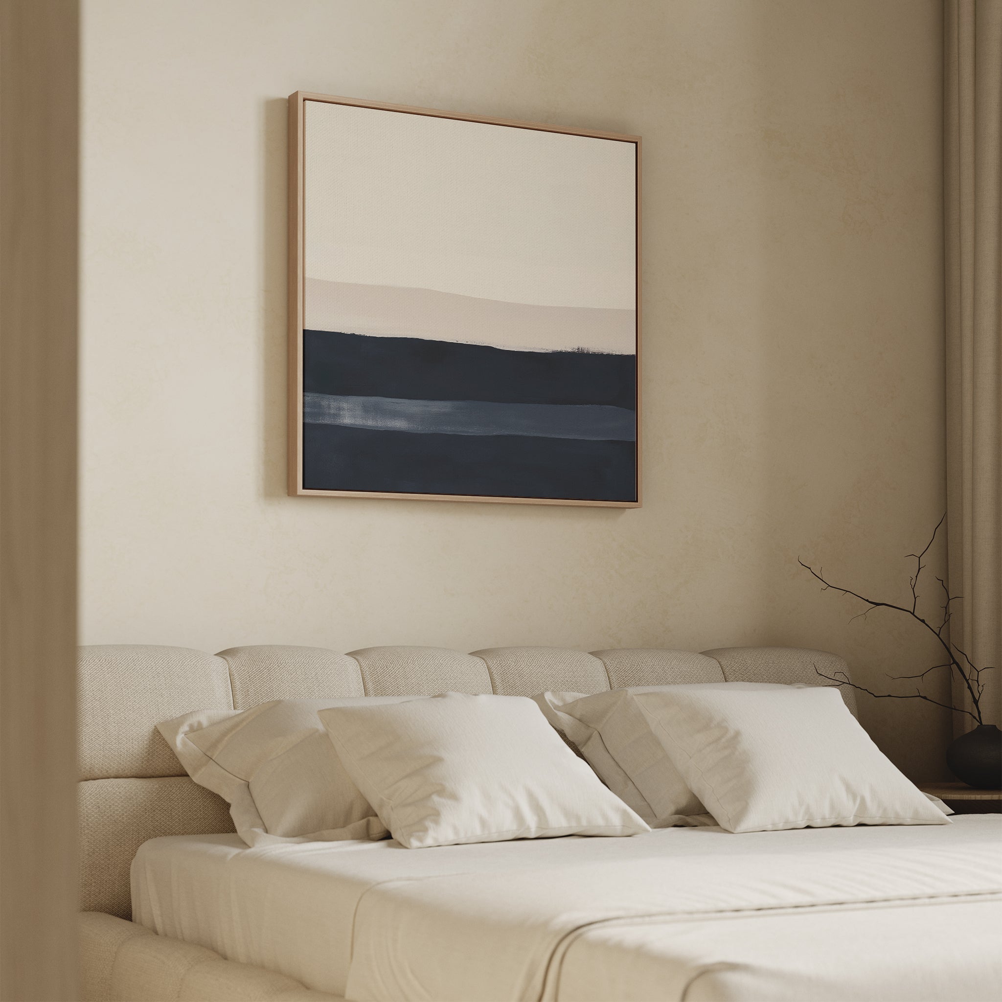 A minimal, neutral-toned bedroom with a beige upholstered bed, white bedding, and four pillows. Above the bed hangs the Ivory Dusk Canvas Art in soft blue and beige tones. A branch on a side table completes this modern look.