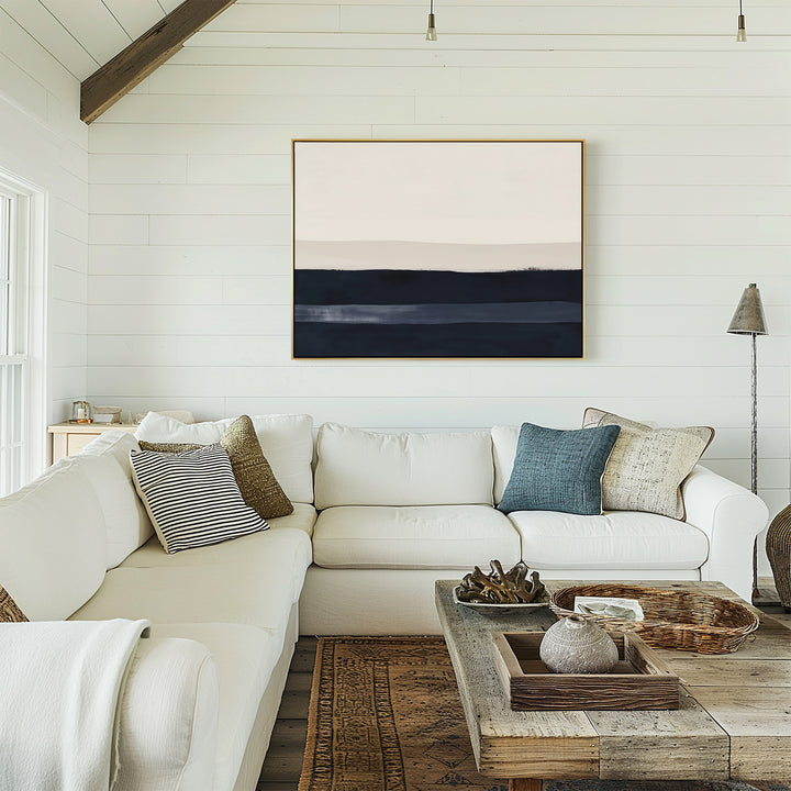 A bright, cozy living room with a white sectional, neutral and blue pillows, a rustic wood coffee table, and the Ivory Dusk Canvas Art – Horizontal as minimalist wall art above the sofa for stylish decor.