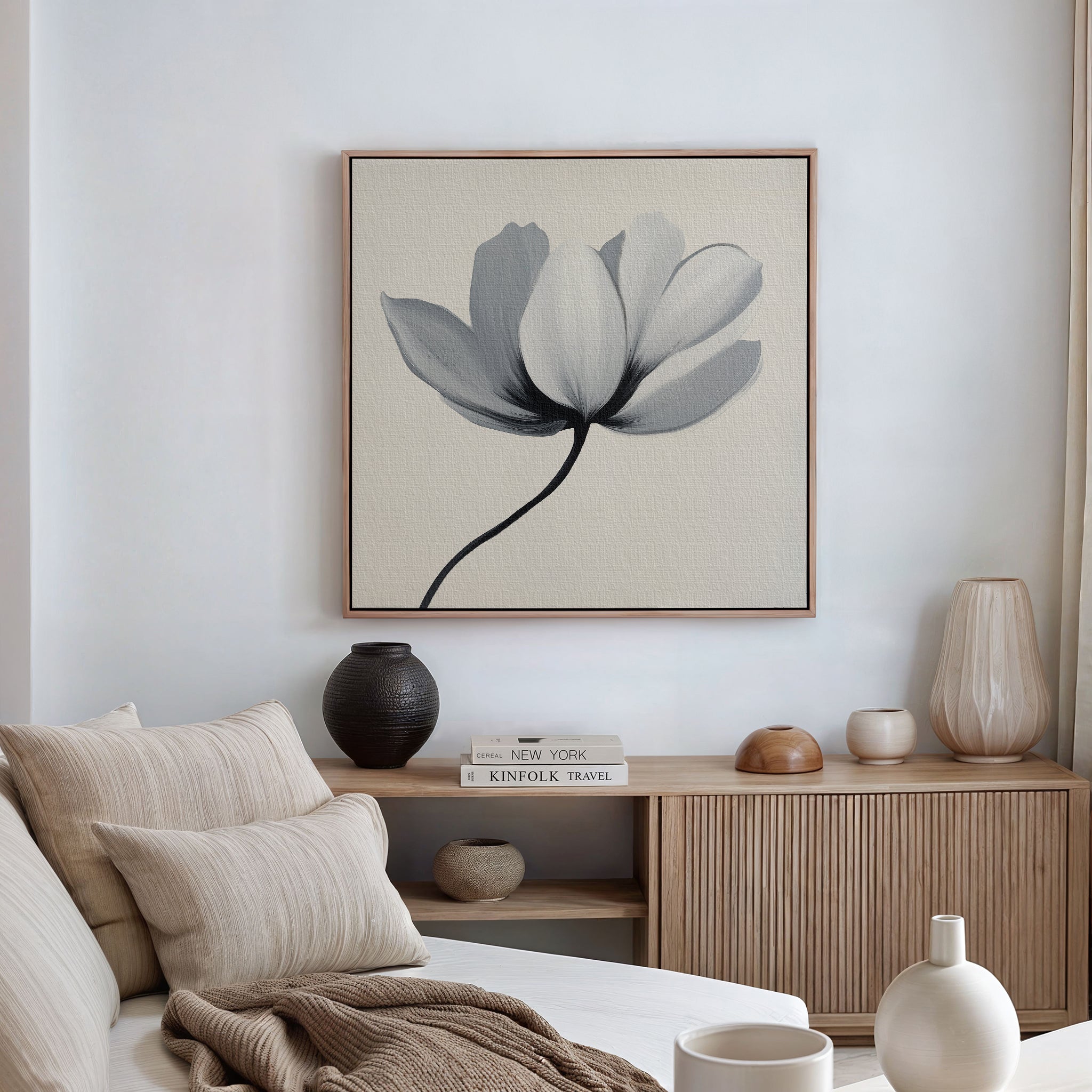 A minimalist living room featuring a beige sofa, neutral cushions, a wooden cabinet with decorative vases, and the Ivory Petal Canvas Art displayed above. Soft natural light filters in through a window dressed with light curtains.