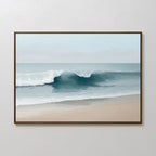 The Lapping Tide Canvas Art features a serene beach scene with a single wave curling toward the sandy shore beneath a pale, overcast sky.