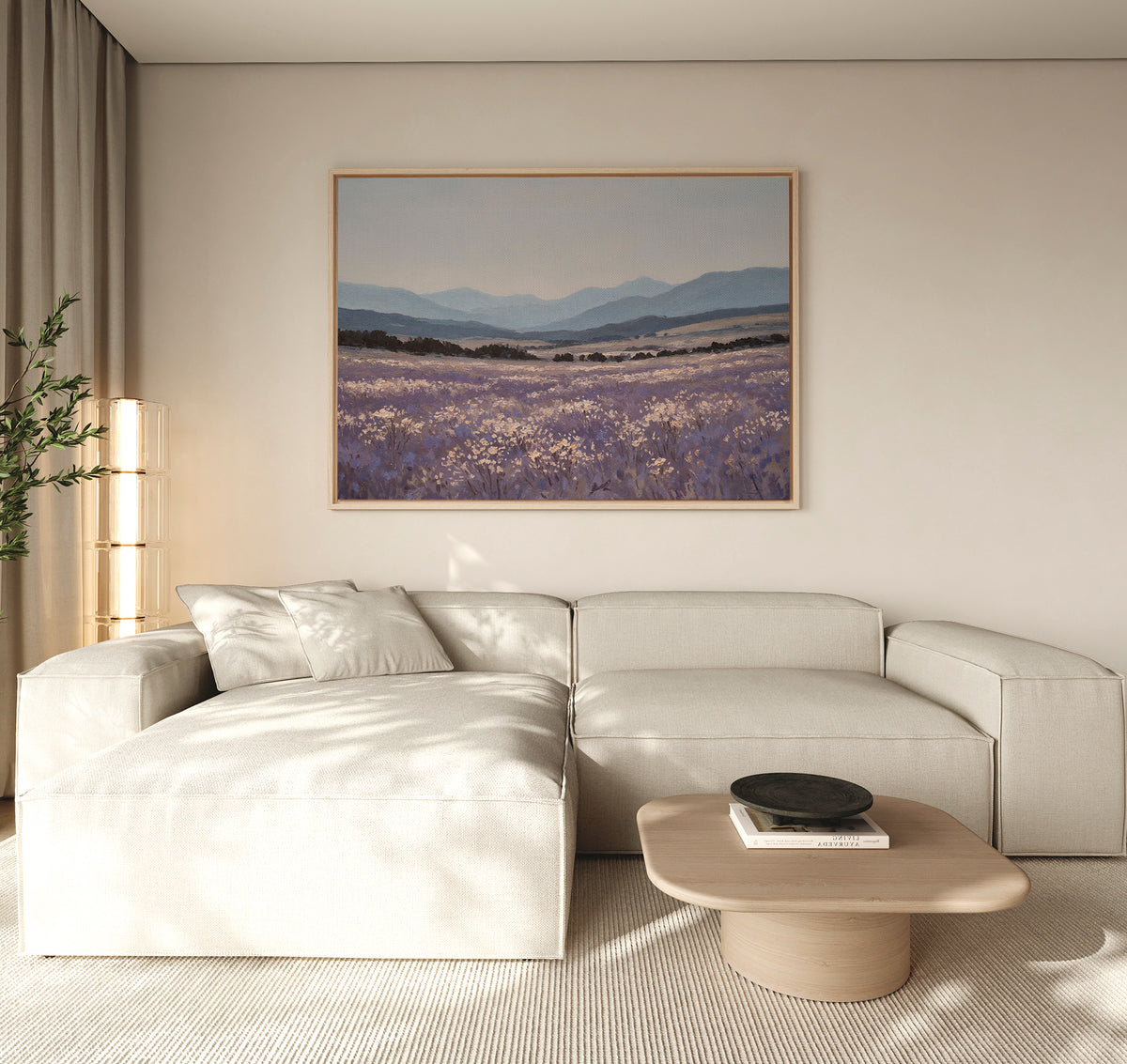 A modern living room with a light beige sectional sofa, wooden coffee table, potted plant, and the Lavender Terrain Canvas Art featuring lavender fields and mountains hanging on a neutral wall. Natural light fills the calming space.