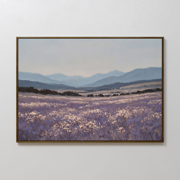 Lavender Terrain Canvas Art: a calming print on canvas showcasing a lavender field, delicate white flowers, rolling hills, and distant blue mountains beneath a pale sky. Perfect minimalist wall art for any white wall.