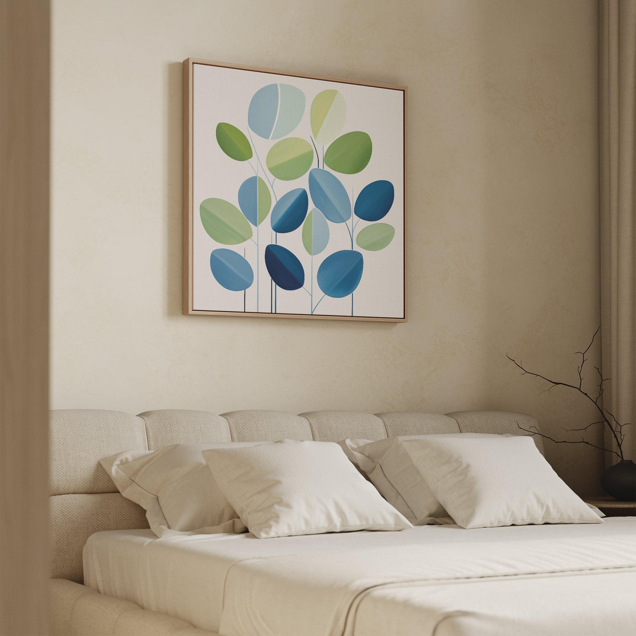 A modern bedroom features a beige upholstered bed with white bedding and four pillows. Above the bed hangs the Layered Stillness Canvas Art, showcasing green and blue leaf shapes. A bare branch sits in a vase on the bedside table.