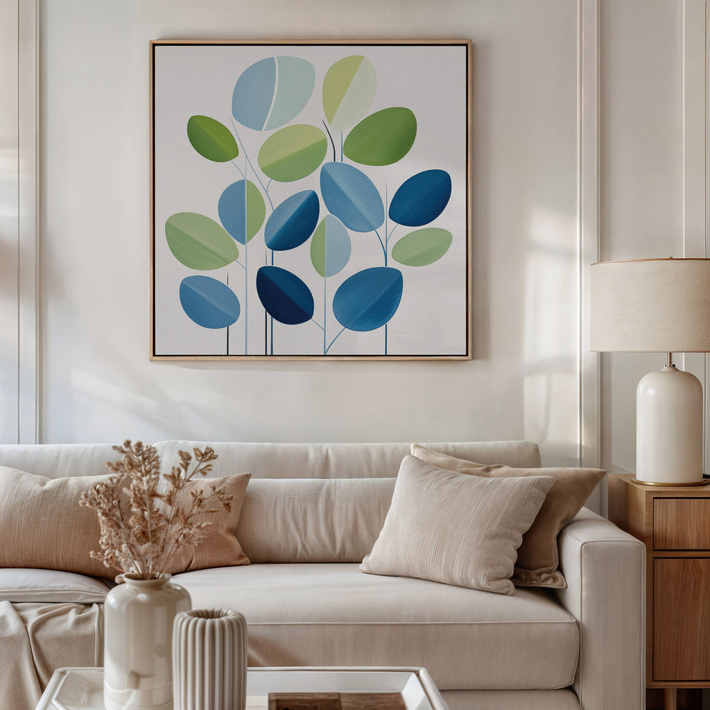 A modern living room features a light beige sofa, neutral pillows, a side table with a lamp, dried flowers in a vase, and the Layered Stillness Canvas Art—an abstract blue and green leaf painting—for stylish decor flair.