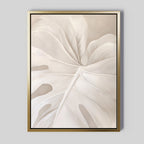 Leaf Whisper Abstract Canvas Art: A framed, minimalist wall art showcasing a close-up of a pale monstera leaf with soft textures and gentle shadows on a light beige background. Ideal for adding serene, Nordic Park-inspired style to your space.