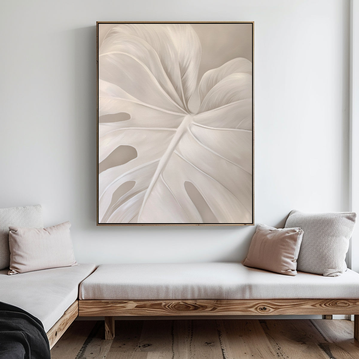 A minimalist living room with light wooden furniture, neutral cushions, and the Leaf Whisper Abstract Canvas Art featuring a pale monstera leaf on a white wall for a Nordic-inspired look.