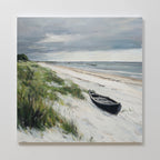 The Lonely Coast Canvas Art features a serene beach with a black boat on white sand, green shore grasses, calm blue water, distant boats, and a cloudy sky—ideal for tranquil decor or as a stunning large wall art piece.