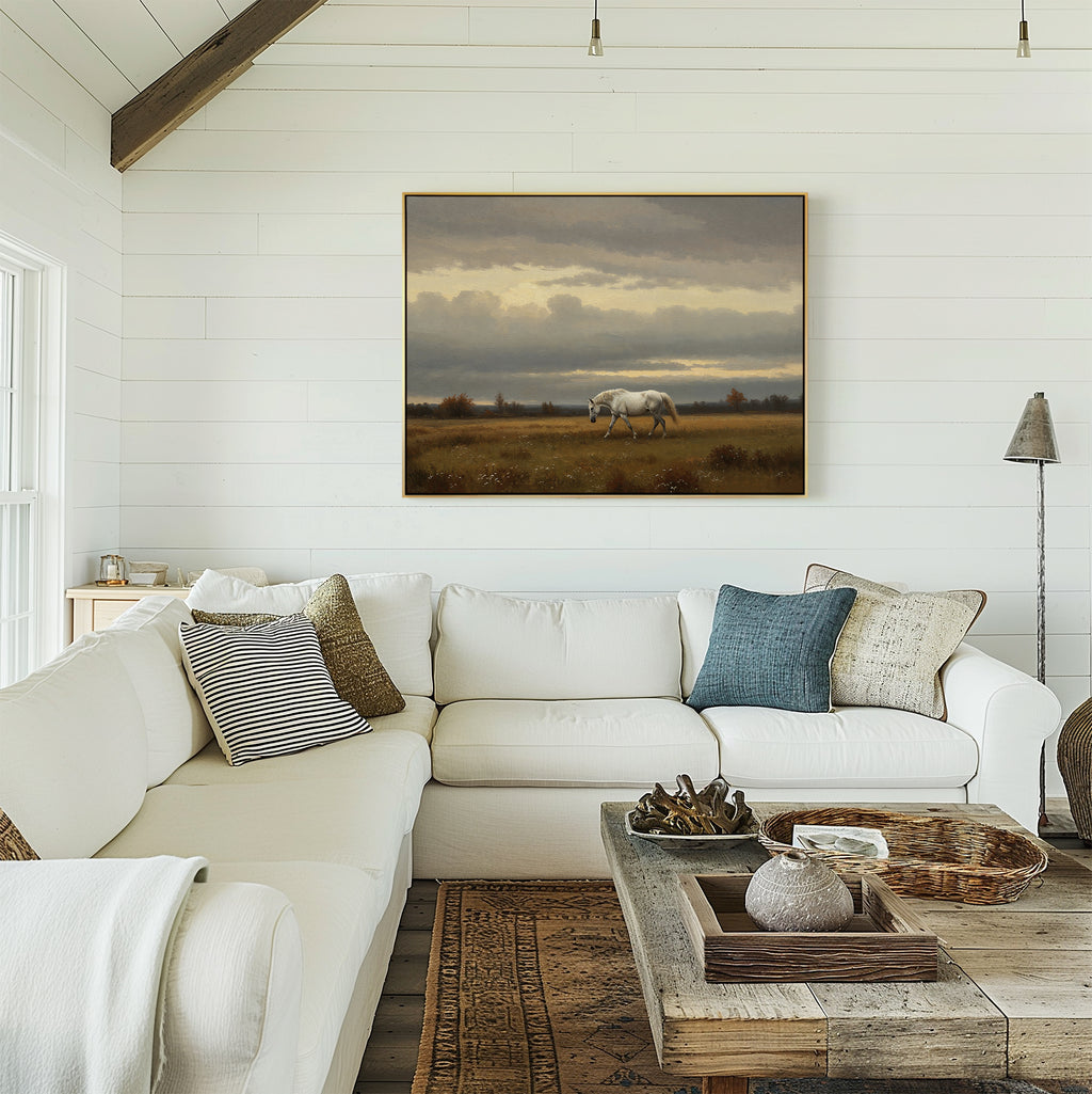 A cozy white living room features a sectional sofa, mixed cushions, and a rustic wood coffee table. Above the sofa, the Low Light Walk Canvas Art hangs on the shiplap wall, adding charm and countryside style to the space.