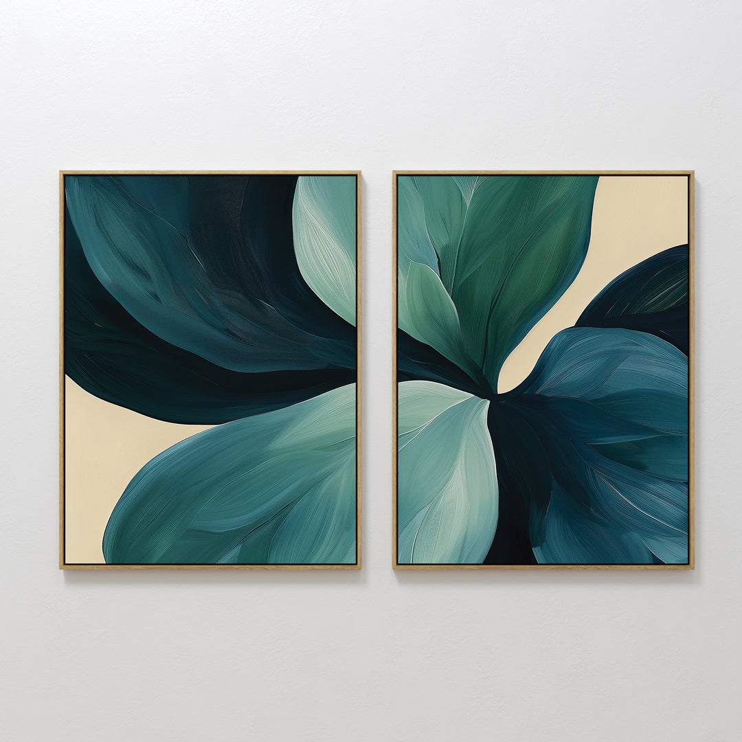 The Lush Teal Foliage Set of 2 features framed abstract canvas art with overlapping teal and green leaves on a beige background—ideal as striking large wall art for your living room decor.