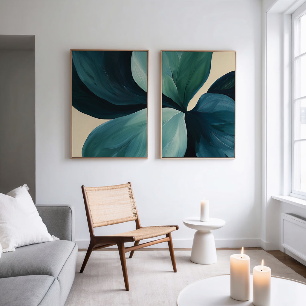 A modern living room with a gray sofa, wooden chair, round side table with a lit candle, and the "Lush Teal Foliage Set of 2" abstract canvas wall art. Sunlight from a large window enhances the contemporary decor.