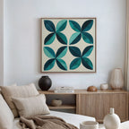 A modern living room with a beige couch, neutral cushions, wood sideboard, and minimalist decor features the Marine Mosaic Canvas Art—an abstract blue and teal petal design—hanging above the sideboard on the white wall.
