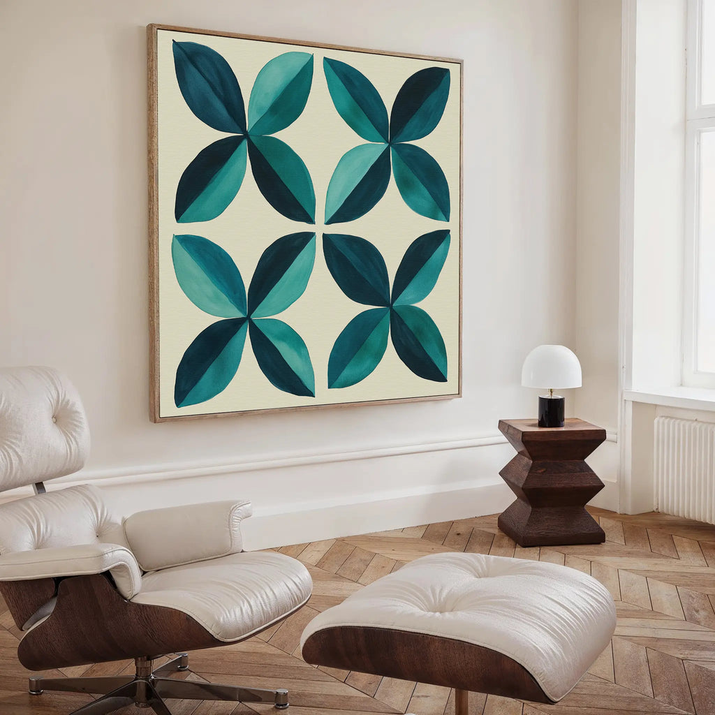 A modern living room with a cream lounge chair and ottoman, a geometric wooden side table with a small white lamp, and striking Marine Mosaic Canvas Art featuring an abstract petal design in blue, teal, and turquoise.