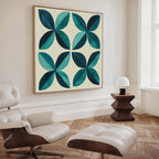 A modern living room with a cream lounge chair and ottoman, a geometric wooden side table with a small white lamp, and striking Marine Mosaic Canvas Art featuring an abstract petal design in blue, teal, and turquoise.