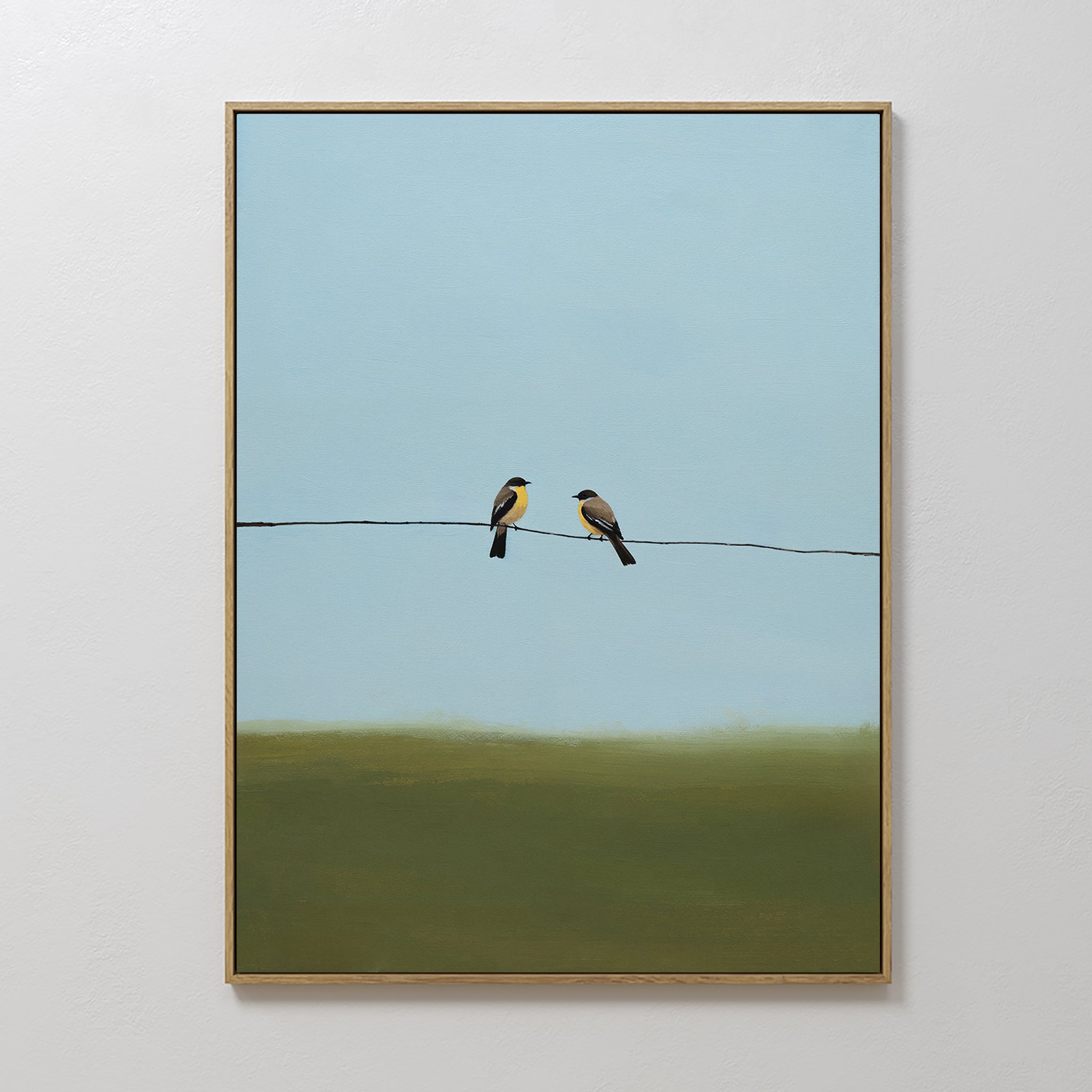 The Meadow Line Canvas Art features two small birds on a wire against a blue sky and green field, making it an ideal framed print for minimalist spaces seeking a serene, calming atmosphere.
