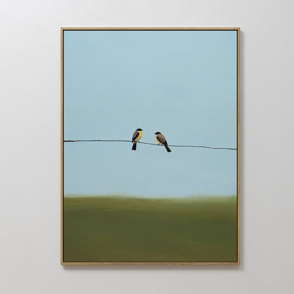 The Meadow Line Canvas Art features two small birds on a wire against a blue sky and green field, making it an ideal framed print for minimalist spaces seeking a serene, calming atmosphere.