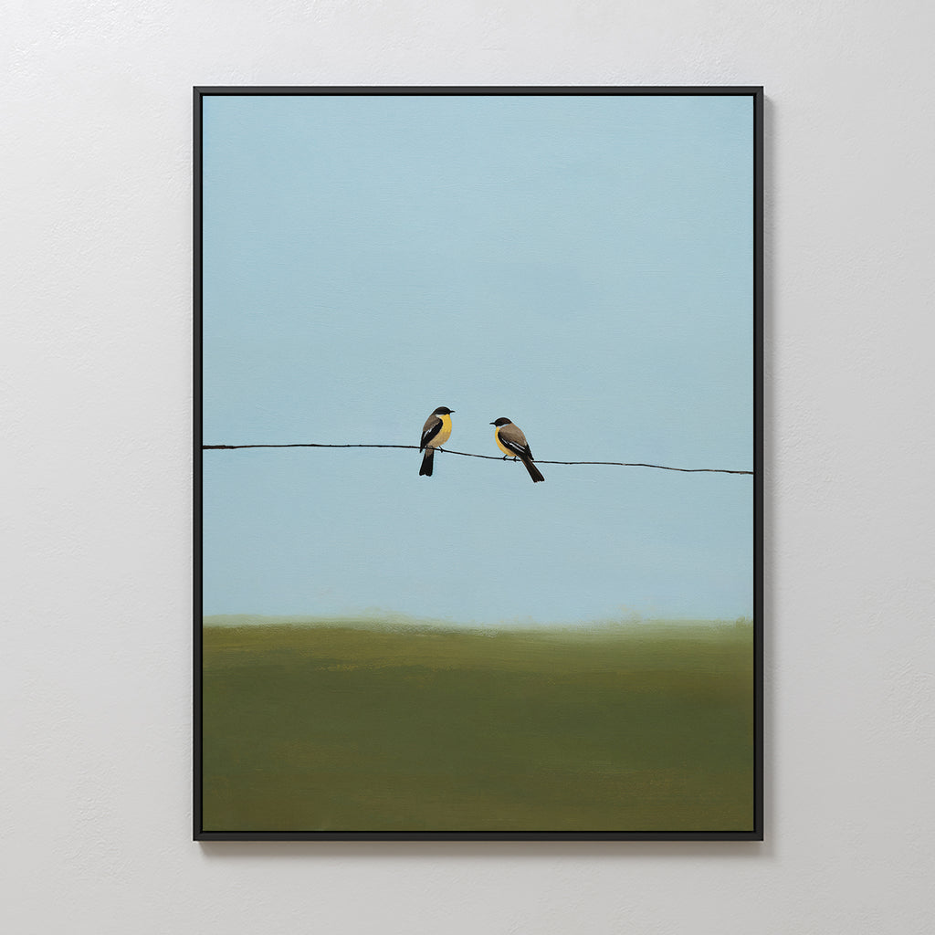 Meadow Line Canvas Art is a minimalist wall print featuring two birds on a wire against a blue sky and green landscape, framed in black—ideal for adding elegance to minimalist interiors.
