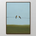 Meadow Line Canvas Art is a framed painting with two birds on a wire, set against a simple blue sky and greenish-brown ground—a perfect accent for minimalist interiors.