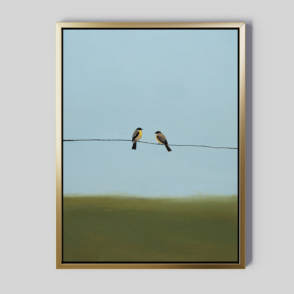 The Meadow Line Canvas Art features two small birds perched on a wire set against a blue sky and green landscape. With its minimalist style and soft colors, this framed print is ideal for modern, minimalist interiors.