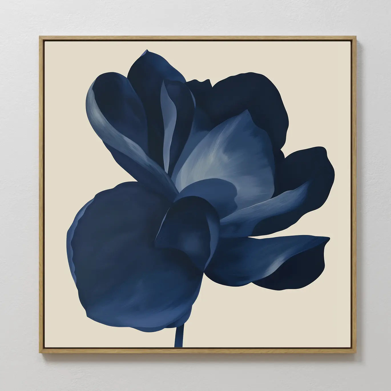 The Midnight Bloom Canvas Art – Square features a large, dark blue flower with soft shading on a light beige background, set in a simple wooden frame—ideal wall art for modern spaces.