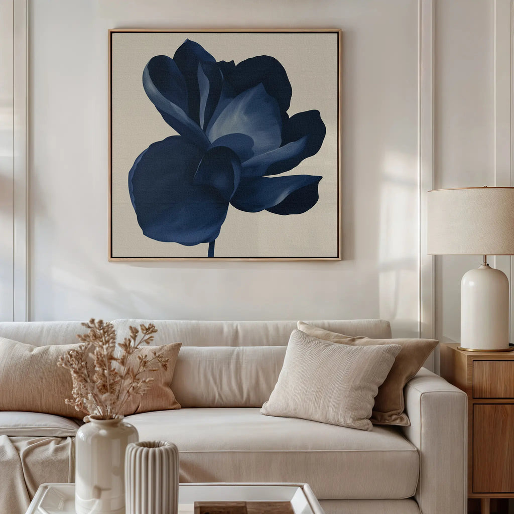 A modern living room with a beige sofa, neutral pillows, a side table topped with a ceramic lamp, and the Midnight Bloom Canvas Art – Square above the couch. Dried flowers in a vase accent the coffee table.